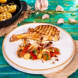 Grillowany tomahawk ze schabu z warzywami, piklowaną szalotką i ziemniakami Grillowany tomahawk ze schabu z warzywami, piklowaną szalotką i ziemniakami